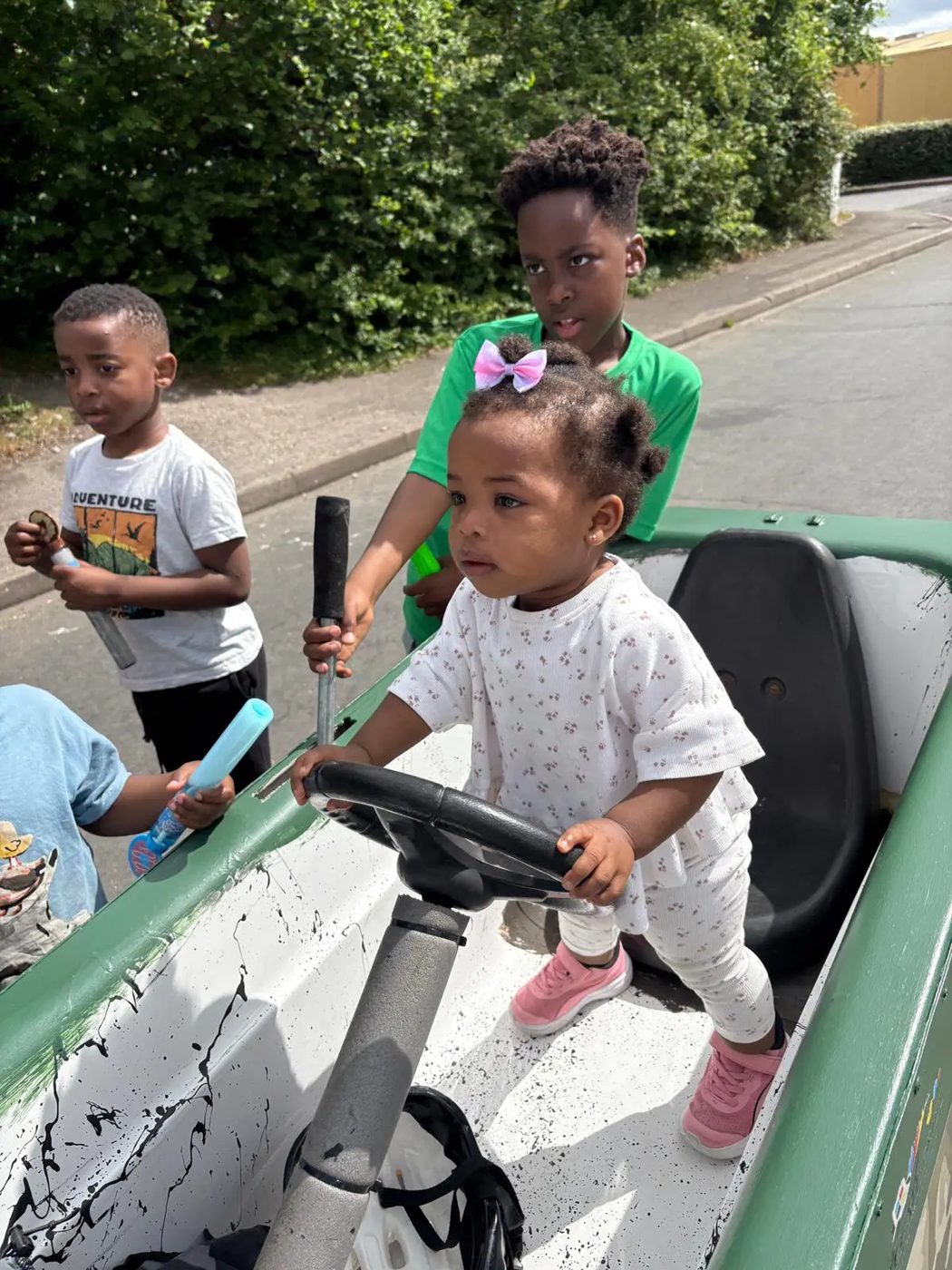 Toddler sitting at the wheel of a soapbox cart