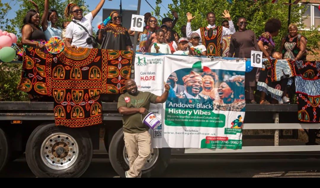 Community members in traditional dress waving from the Heritage & Hope float