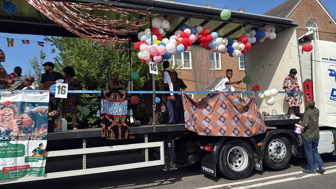 Heritage & Hope carnival float decorated with balloons and flags